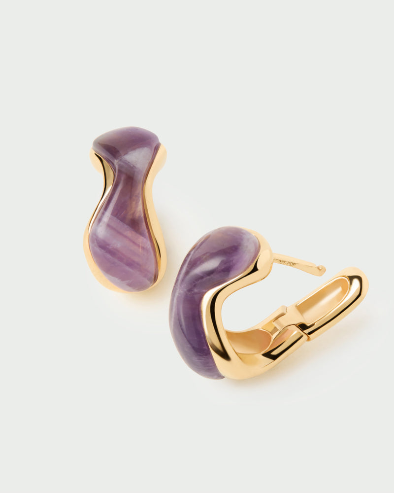 Gold-plated fluid huggie earrings with a curved purple gemstone
