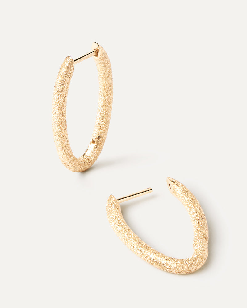 Distinctive oval hoop earrings in solid yellow gold with a sandblast finish