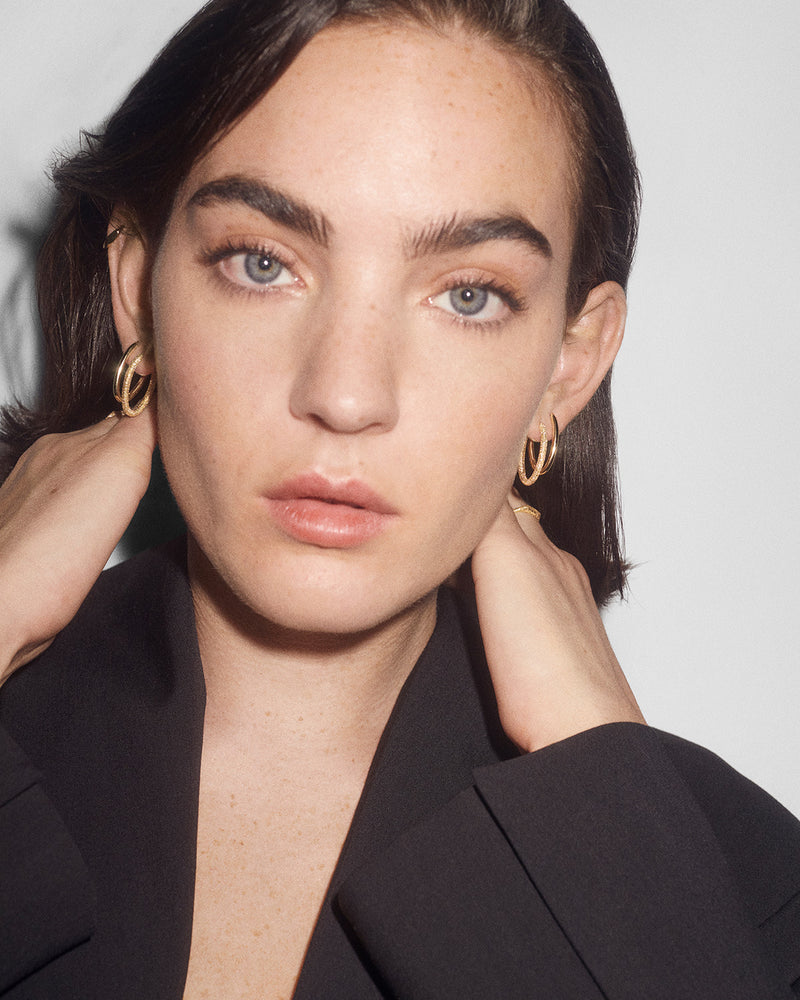 Distinctive oval hoop earrings in solid yellow gold with a sandblast finish