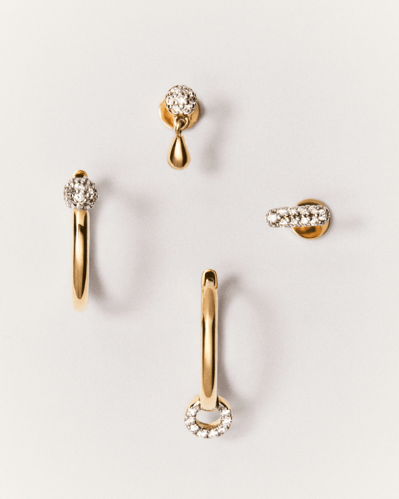 Dainty ear piercing in solid yellow gold set with pavé lab-grown diamonds and a small drop pendant